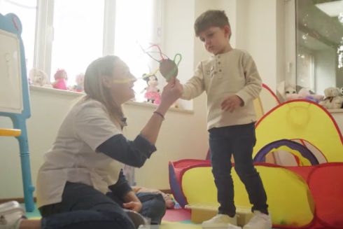 Дете участва в игри и творчески дейности за разпознаване и изразяване на емоции по време на терапевтична сесия.